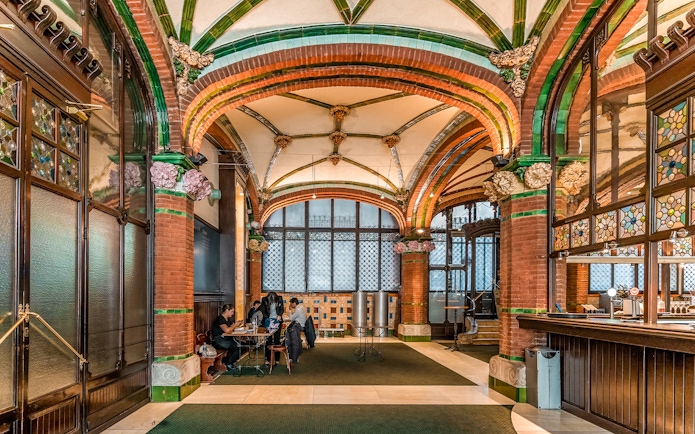 Hall inside Palau de la Musica Catalana with stained glass and ornate arches.