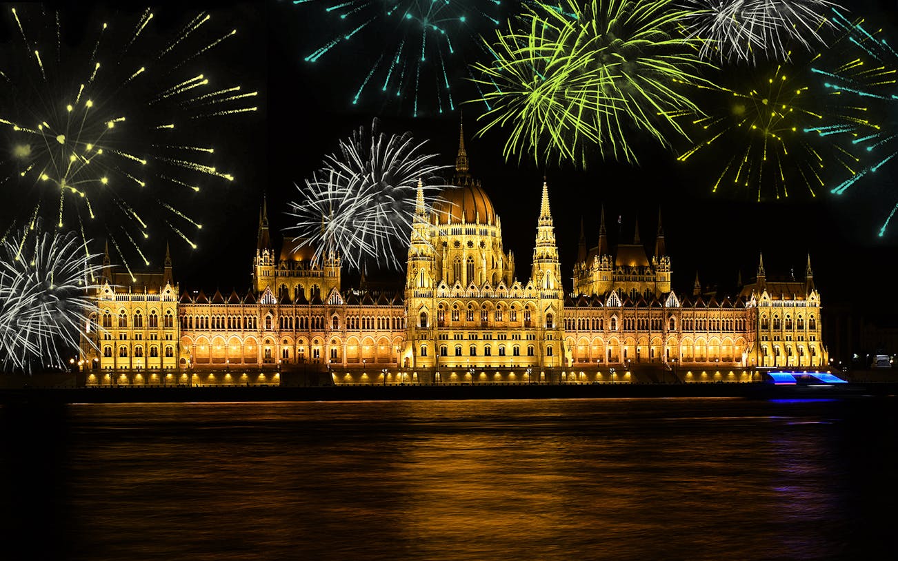 Budapest Parliament lit up with fireworks during a dinner cruise on the Danube River.