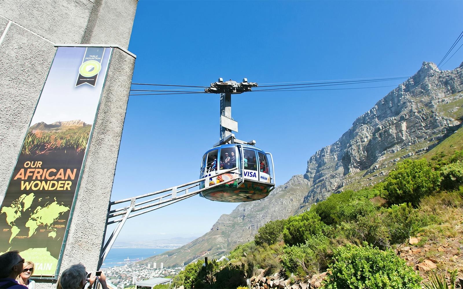 Cable car ascending Table Mountain, Cape Town, with scenic views of the landscape.