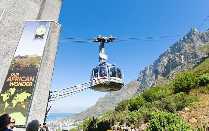 Cable car ascending Table Mountain, Cape Town, with scenic views of the landscape.