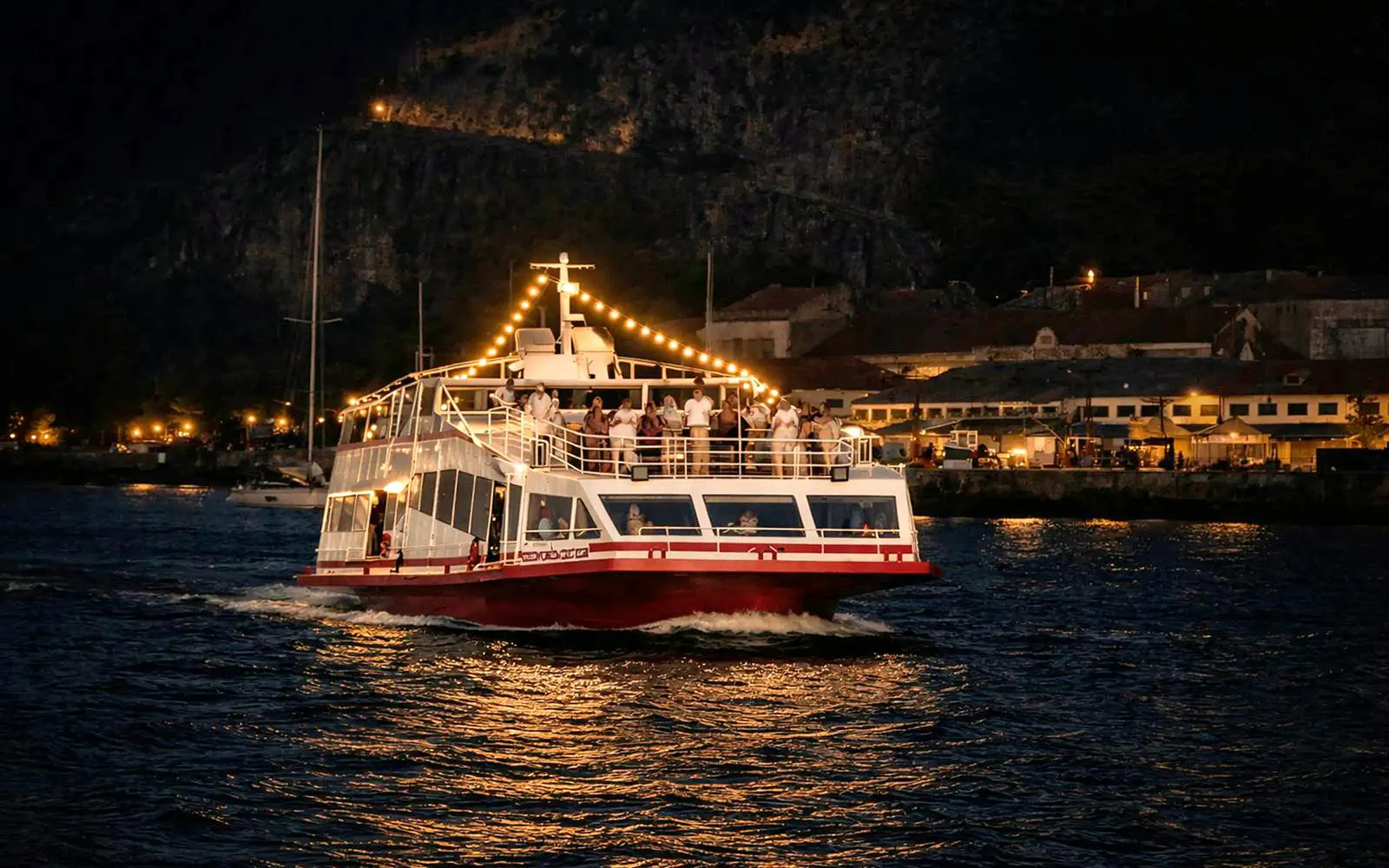 Lisbon boat cruise at sunset with DJ and open bar, guests enjoying the view.