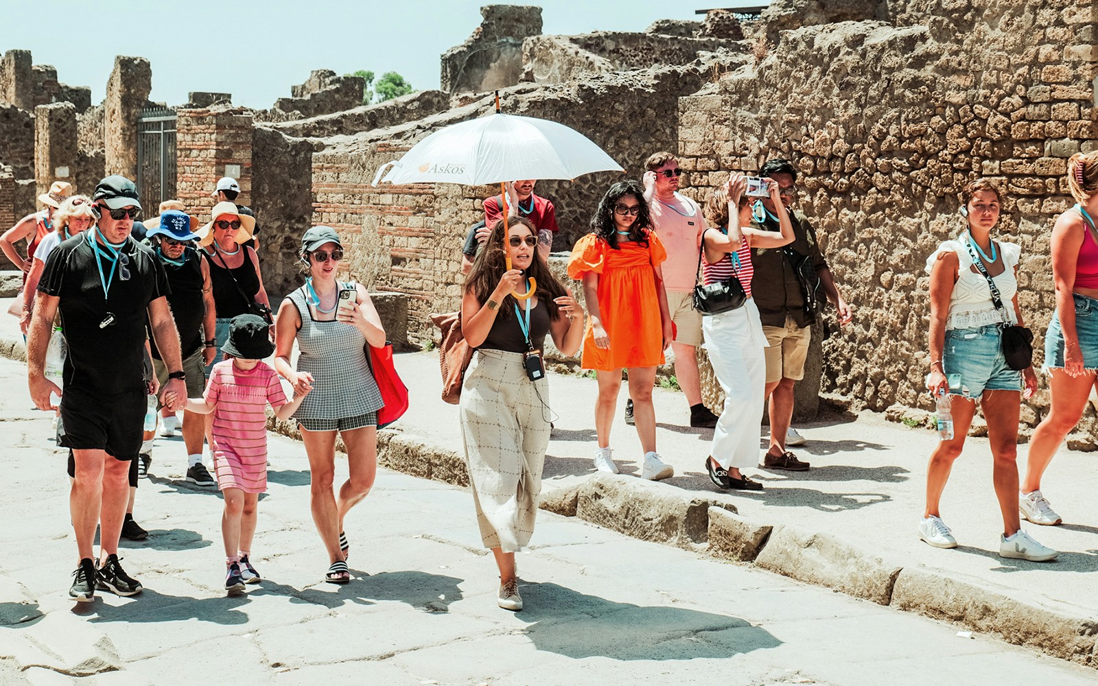 Tourists exploring ancient ruins with expert guidance at Pompeii, Italy.