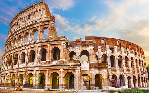 Colosseum in Rome under a blue sky, part of skip-the-line tour package.