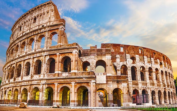 Colosseum in Rome under a blue sky, part of skip-the-line tour package.
