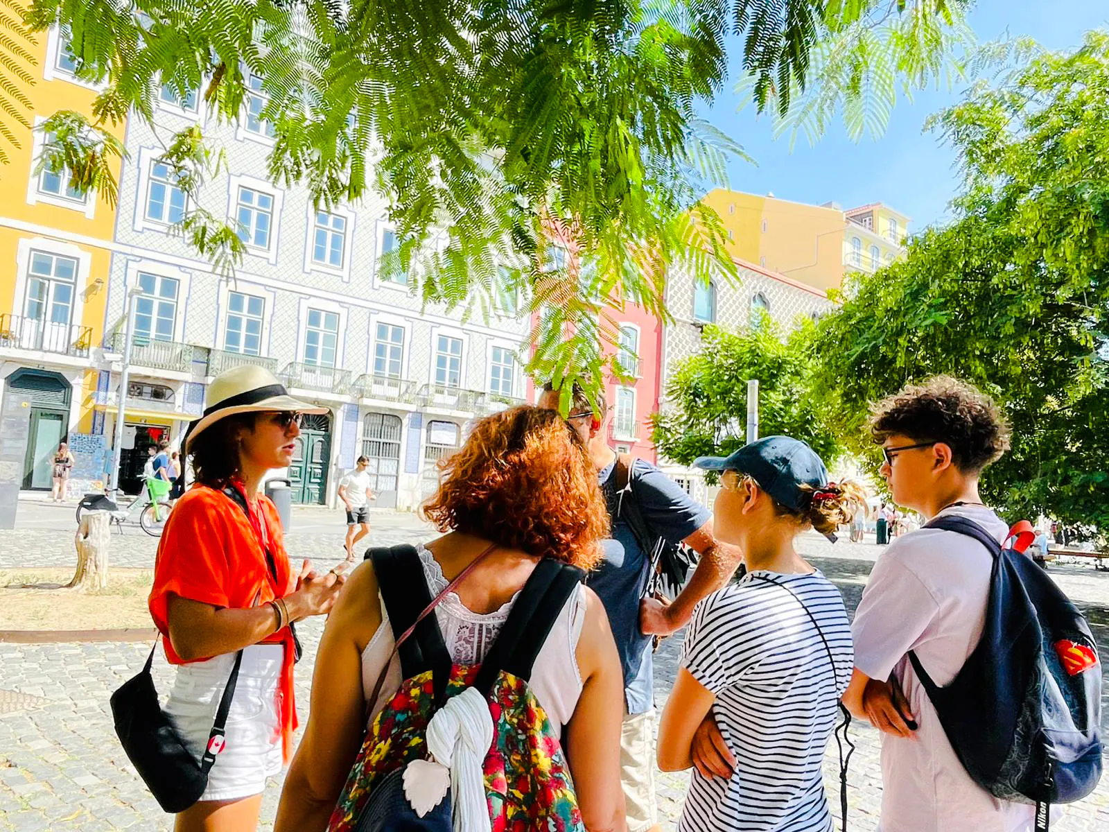 Tour group in Lisbon listening to a guide during a vegan food and culture walking tour.