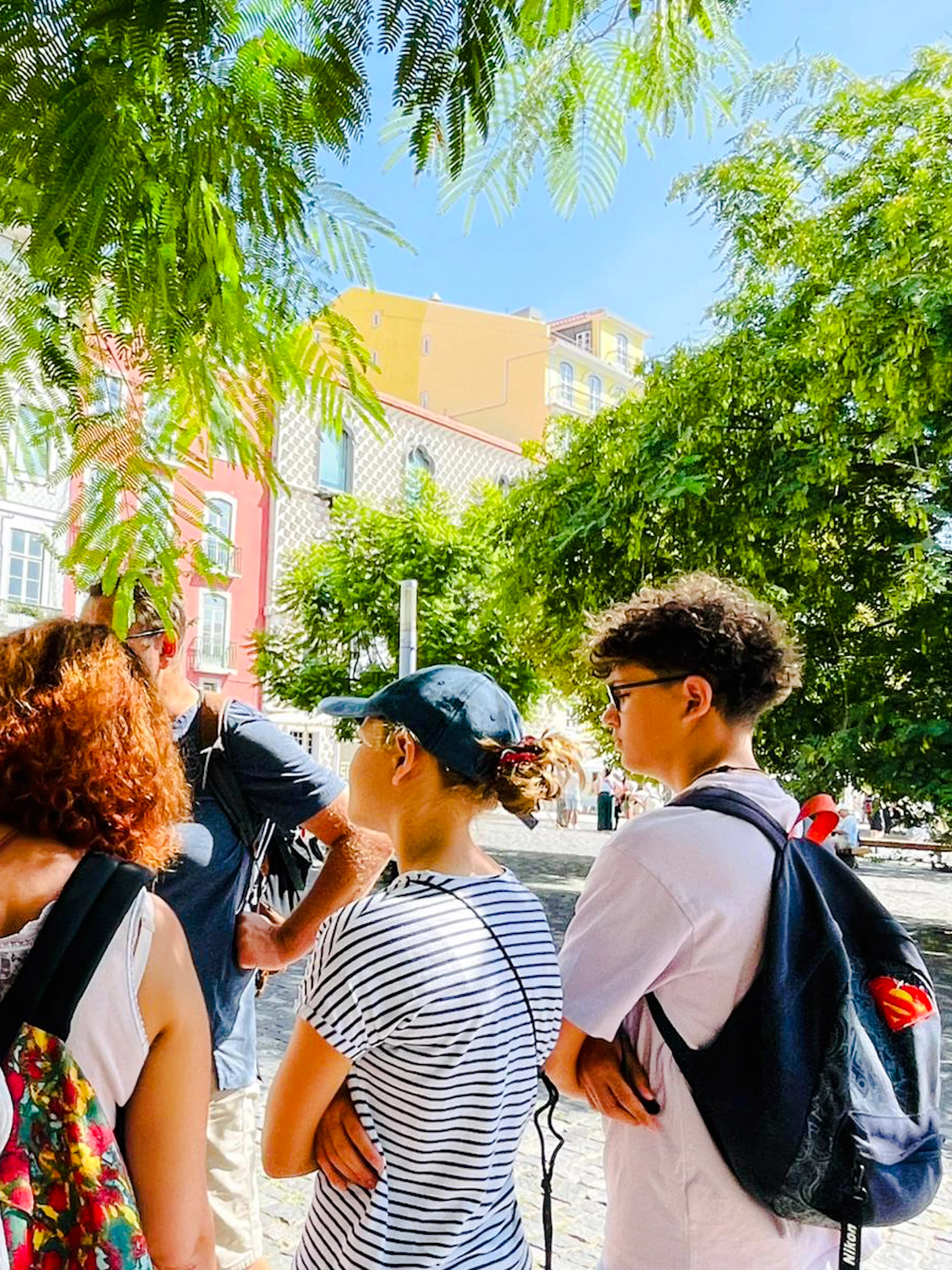 Tour group in Lisbon listening to a guide during a vegan food and culture walking tour.