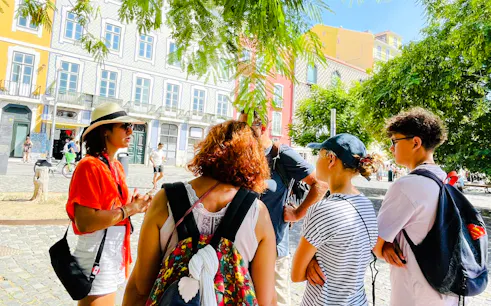 Tour group in Lisbon listening to a guide during a vegan food and culture walking tour.