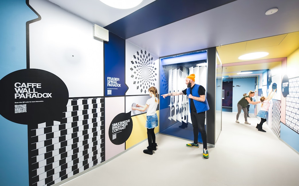 Visitors interacting with optical illusions at Paradox Museum Stockholm.
