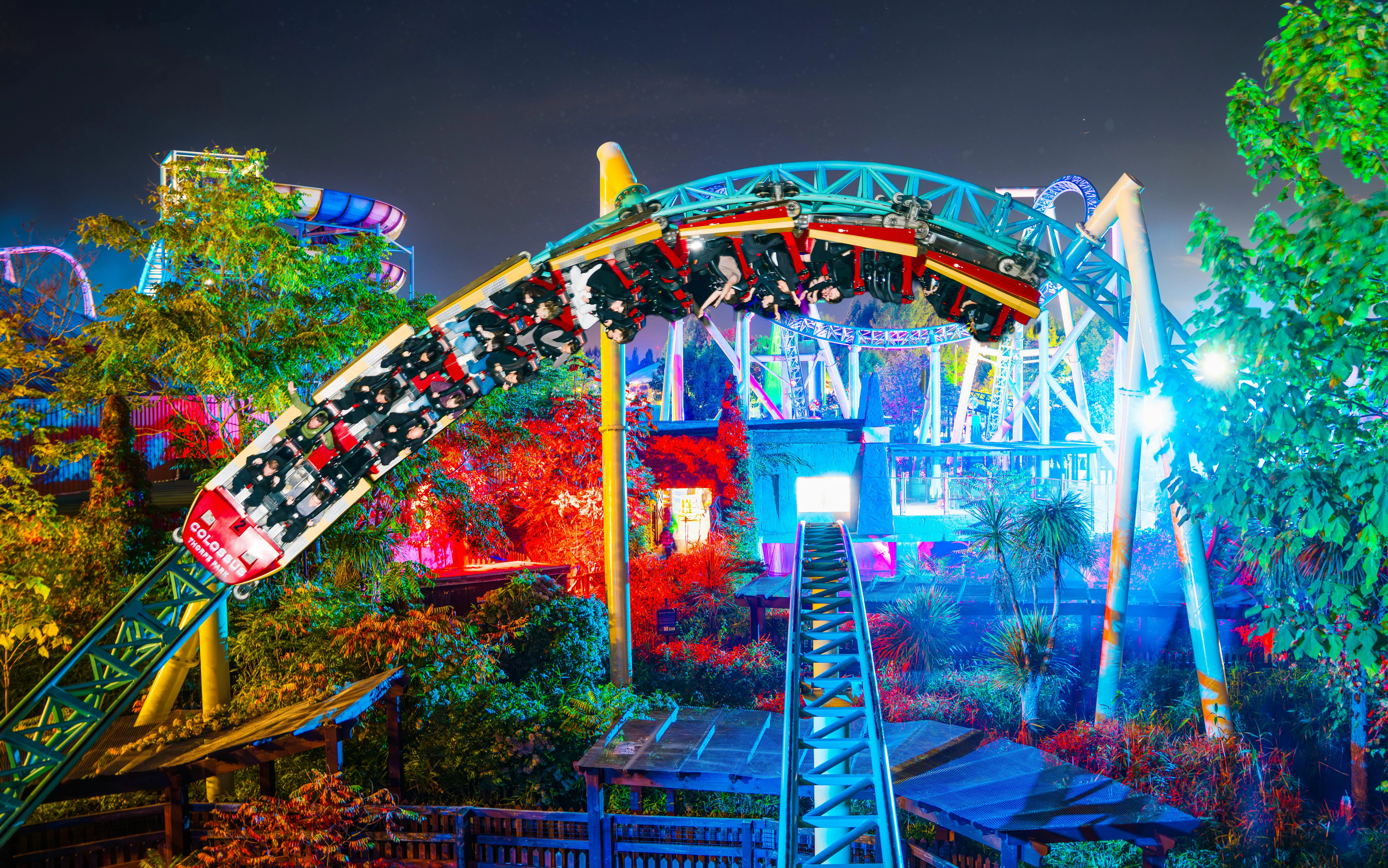 Roller coaster at night during Thorpe Park Fright Nights, illuminated with colorful lights.