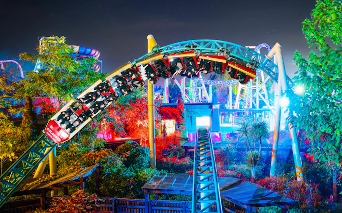 Roller coaster at night during Thorpe Park Fright Nights, illuminated with colorful lights.