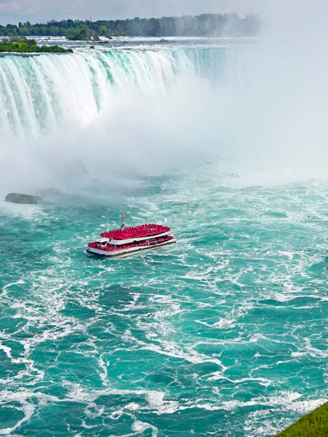 Aerial view of Niagara Falls with tour boat in the water.