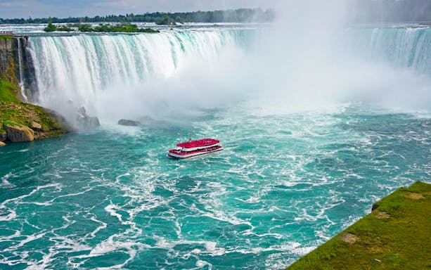 Aerial view of Niagara Falls with tour boat in the water.