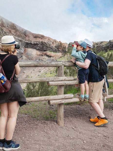 Visitors hiking along a trail on Mount Vesuvius, viewing the crater.