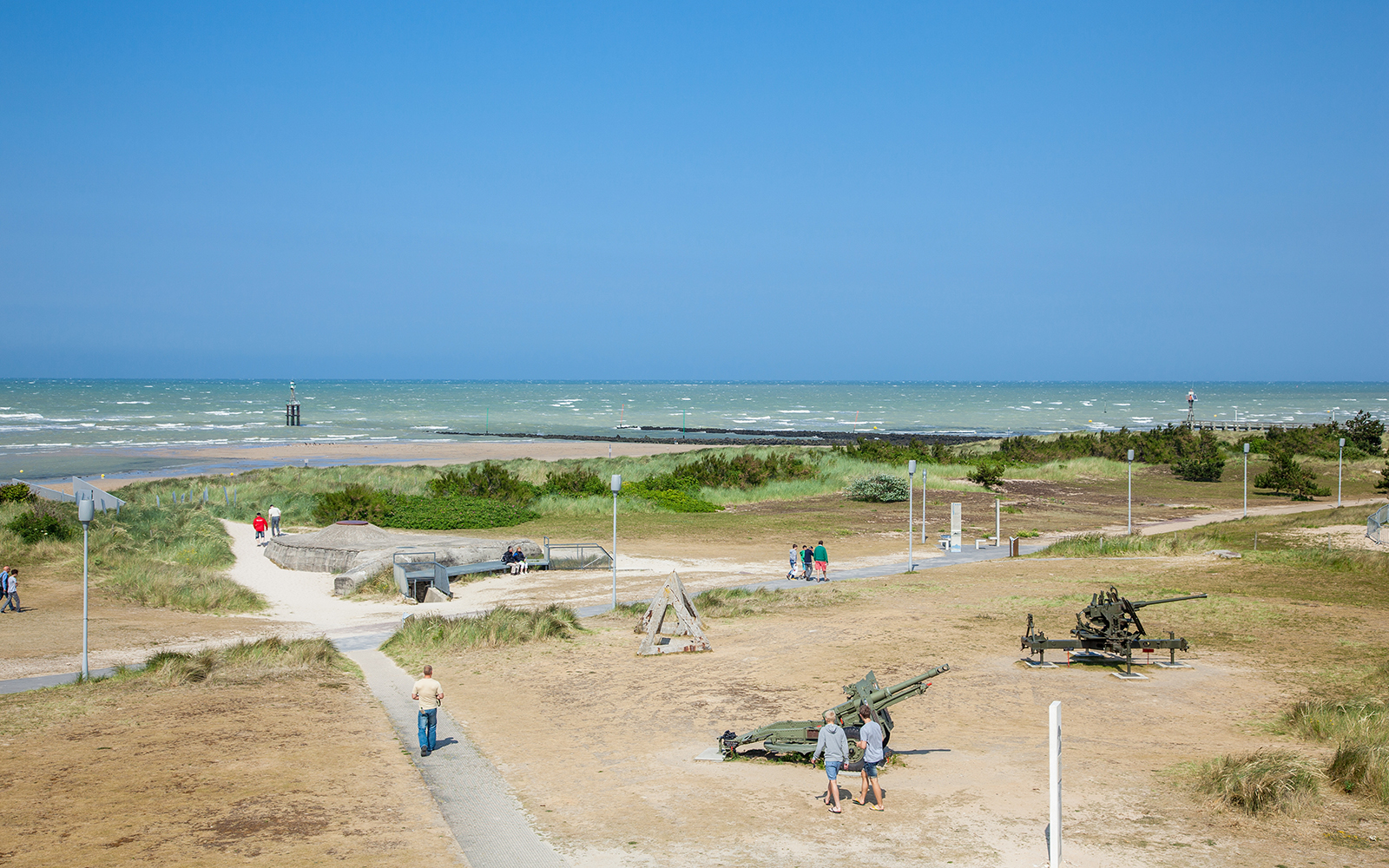Normandy beach with WWII bunkers and artillery, part of D-Day tour from Paris, Canada sector.