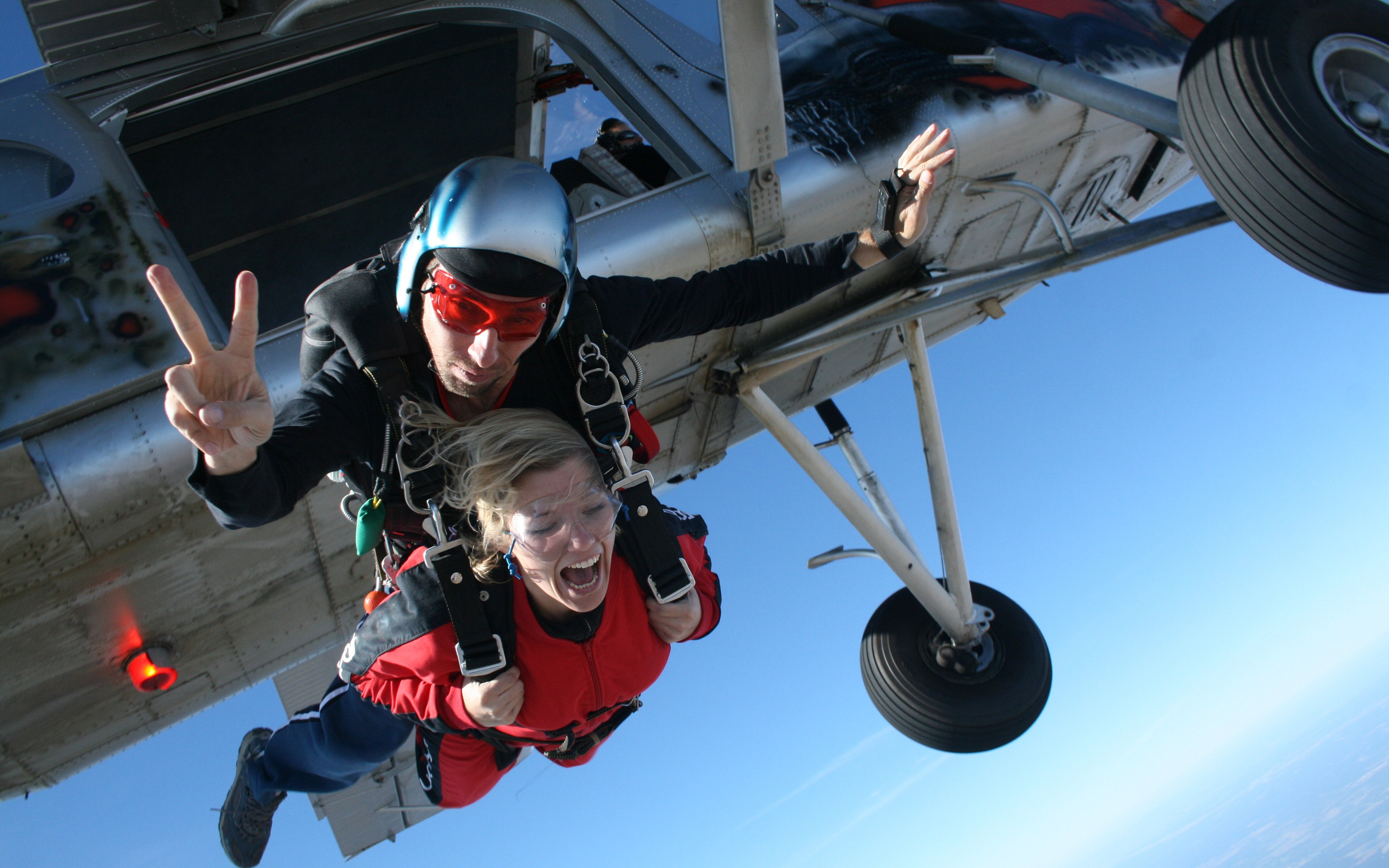 Tandem skydiving jump from a plane with an instructor and participant in freefall.