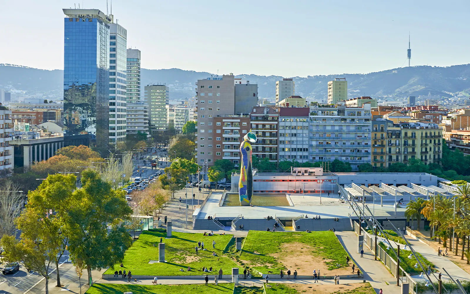 Barcelona skyline with Joan Miró Square and sculpture in foreground.
