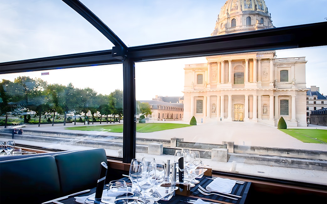 Dining table inside Bustronome Paris with view of Les Invalides.