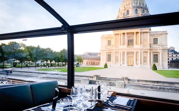 Dining table inside Bustronome Paris with view of Les Invalides.