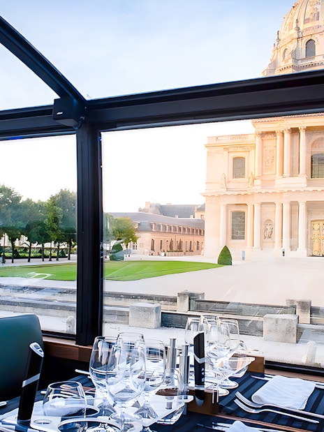 Dining table inside Bustronome Paris with view of Les Invalides.