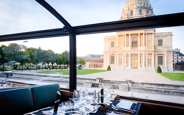 Dining table inside Bustronome Paris with view of Les Invalides.
