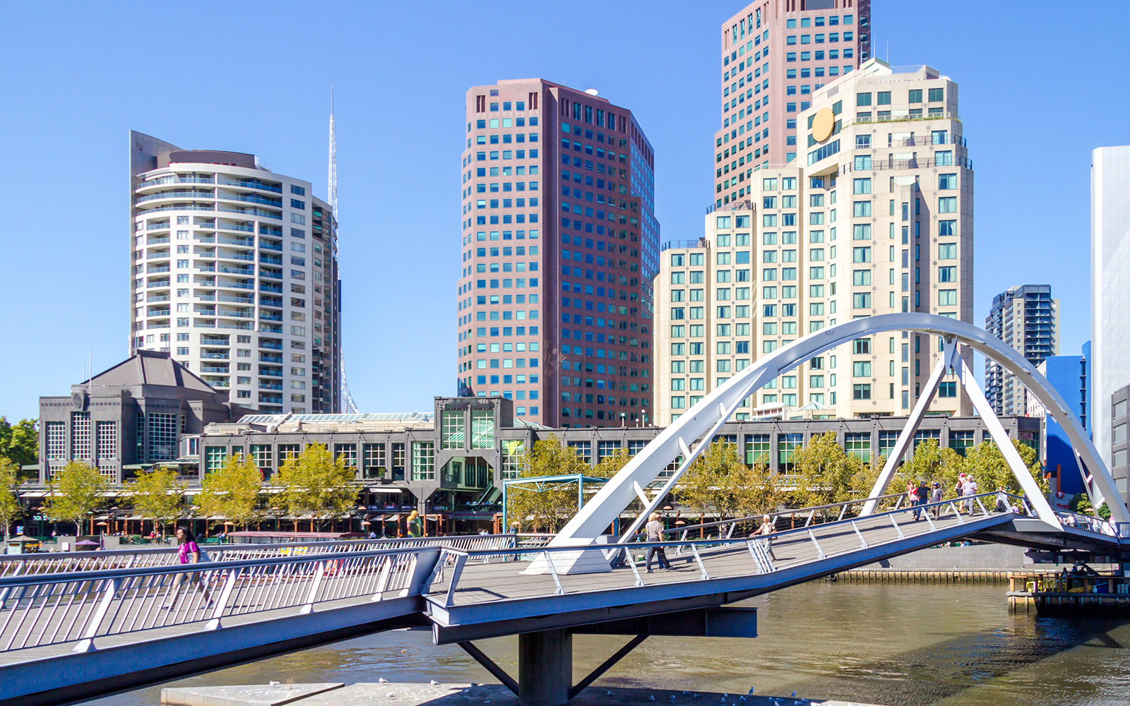 Southgate pedestrian bridge over Yarra River with Melbourne skyline in the background.