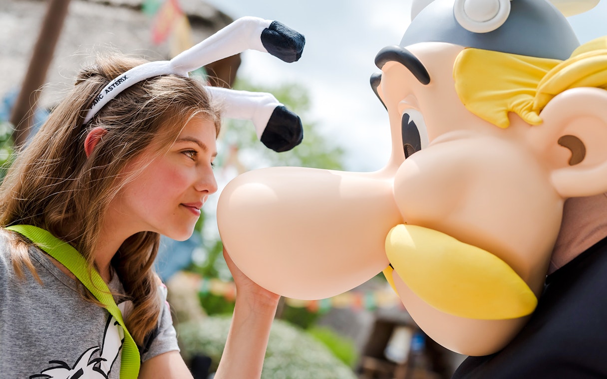 Young visitor interacting with Asterix character at Parc Asterix, France.
