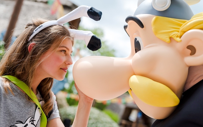 Young visitor interacting with Asterix character at Parc Asterix, France.