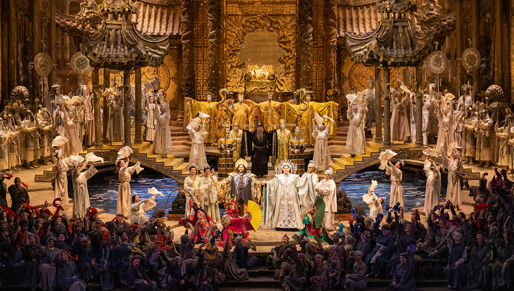 Opera performance of Turandot with elaborate costumes and grand stage set.