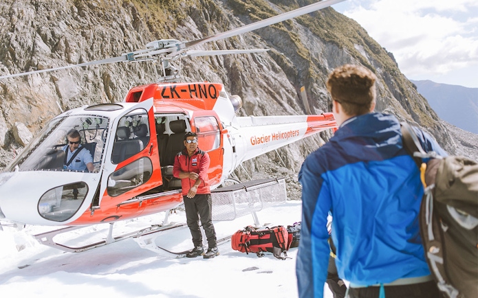 Guide and helicopter at Fox Glacier for a heli hike tour.