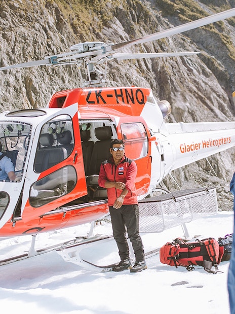 Guide and helicopter at Fox Glacier for a heli hike tour.