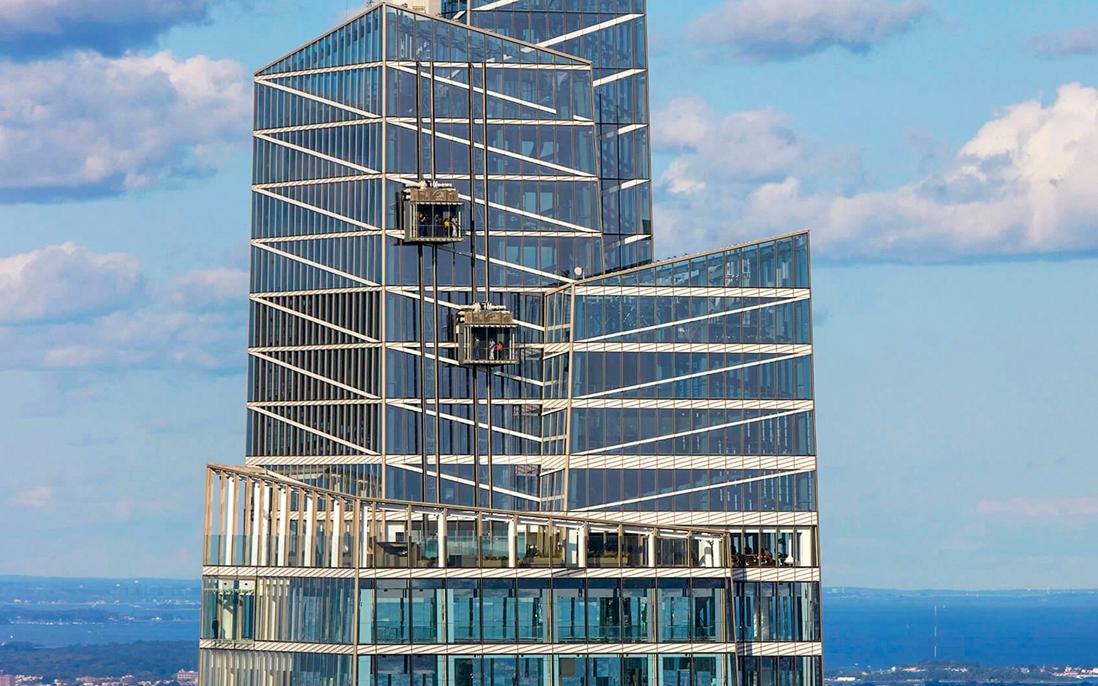 Glass elevator ascending inside SUMMIT One Vanderbilt, New York City, offering panoramic views.