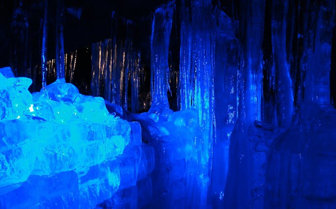 Ice formations inside Fugaku Wind Cave, Japan, illuminated in blue light.