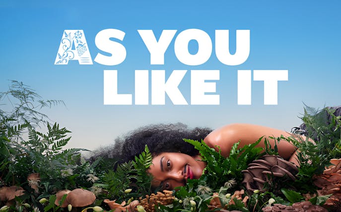 As You Like It text with person lying among greenery and mushrooms.