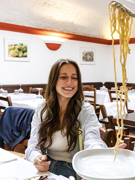 Two women enjoying spaghetti at a restaurant during Taste of Testaccio: Food & Market Tour.