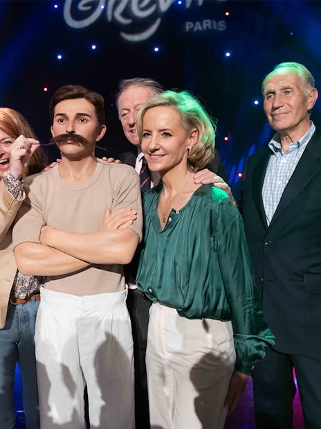 Group posing with Pierre de Coubertin wax figure at Grévin Paris.