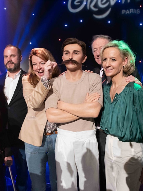 Group posing with Pierre de Coubertin wax figure at Grévin Paris.