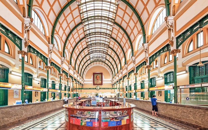 Saigon Central Post Office interior with arched ceiling and customer service counters.