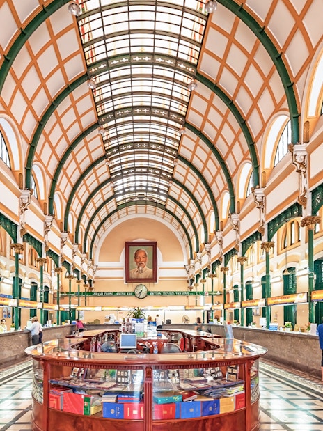 Saigon Central Post Office interior with arched ceiling and customer service counters.