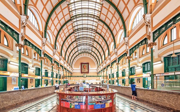 Saigon Central Post Office interior with arched ceiling and customer service counters.