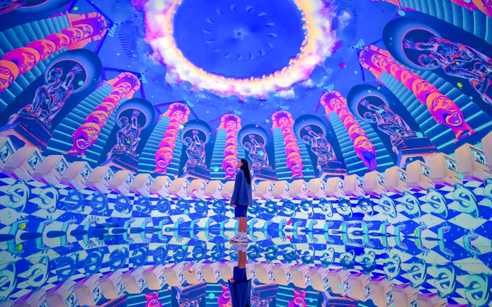 Futuristic art installation with neon colors and mirrored reflections at House Of Hype.