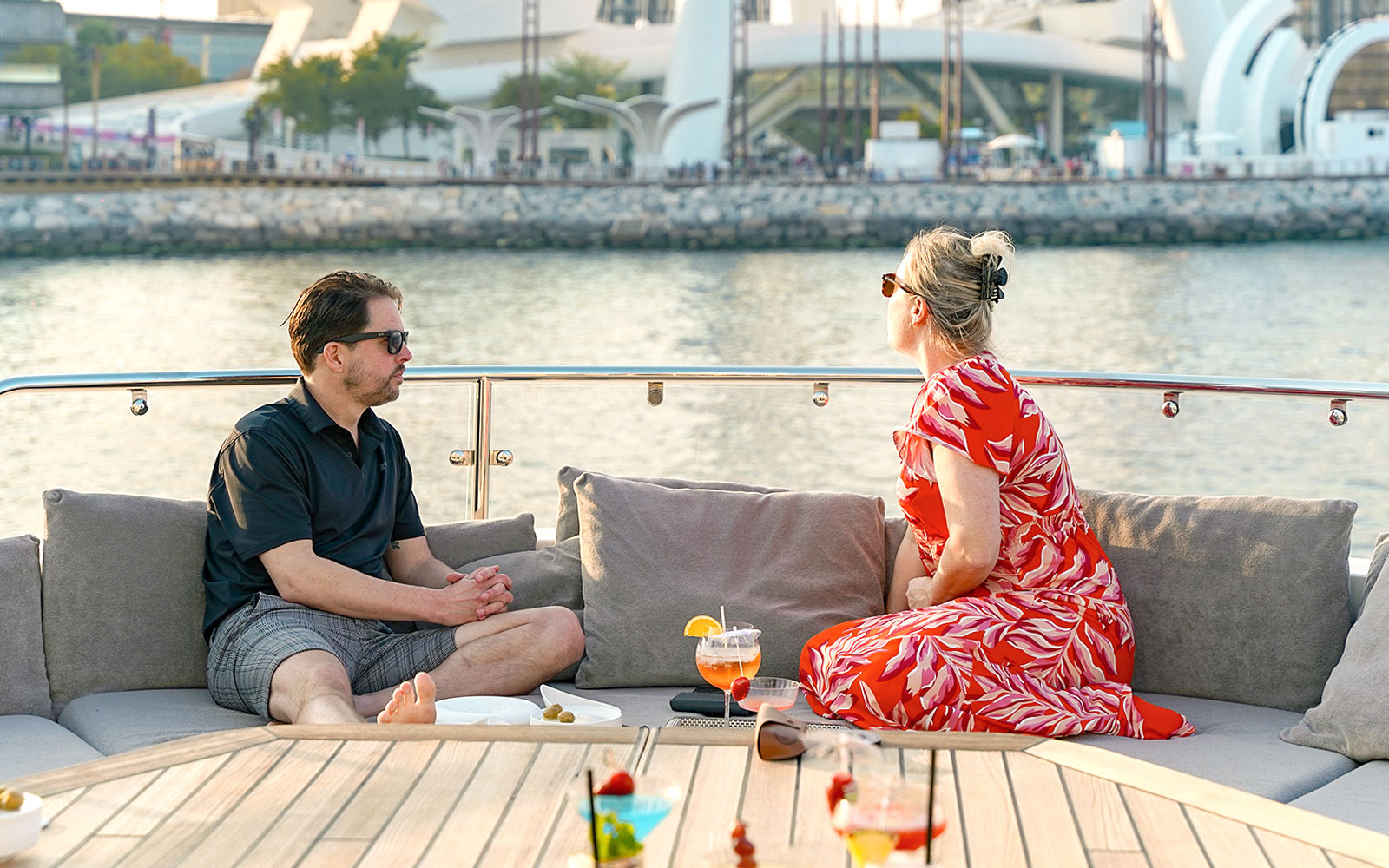 Couple enjoying drinks on a Sunseeker superyacht with waterfront view.