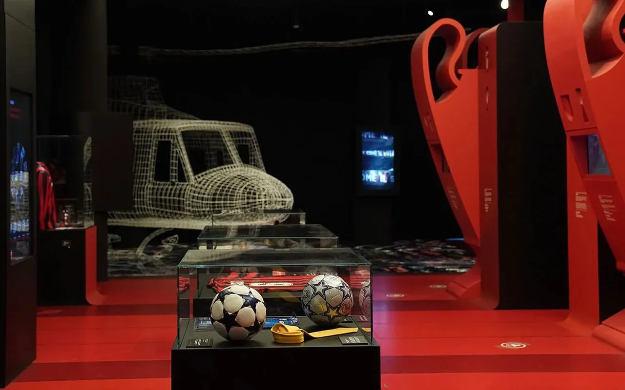 Soccer memorabilia display at Casa Milan Museum, Italy, featuring footballs and trophies.