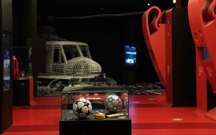 Soccer memorabilia display at Casa Milan Museum, Italy, featuring footballs and trophies.
