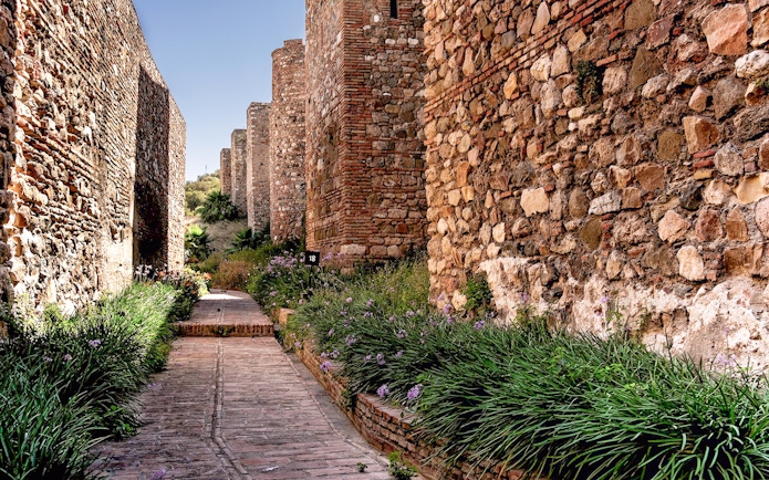 Pathway between ancient stone walls at Alcazaba in Málaga.