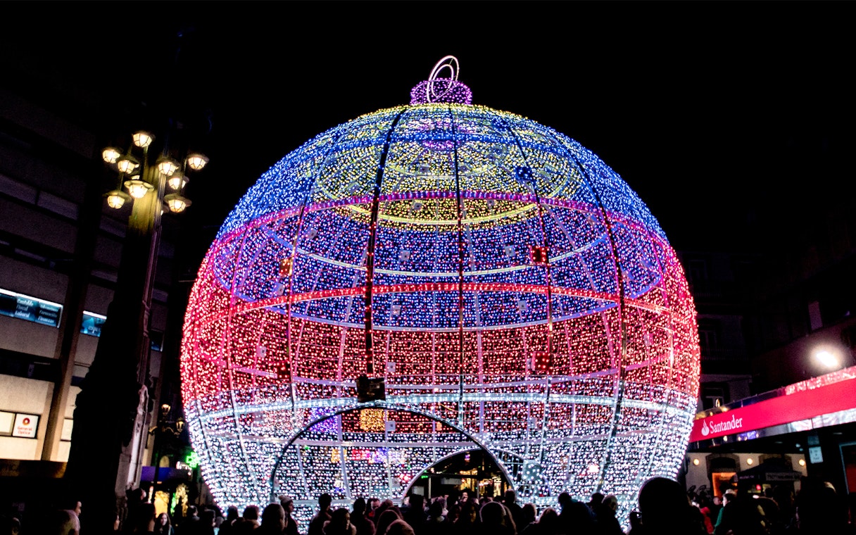 Giant illuminated Christmas ornament in Paris street.