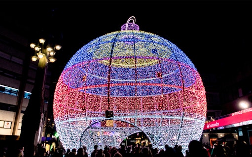 Giant illuminated Christmas ornament in Paris street.