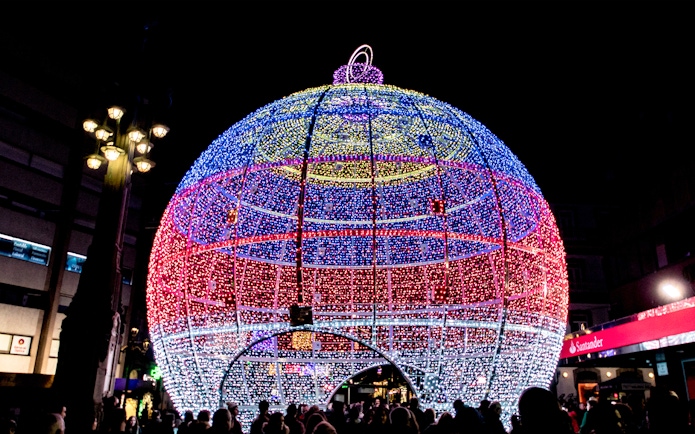 Giant illuminated Christmas ornament in Paris street.