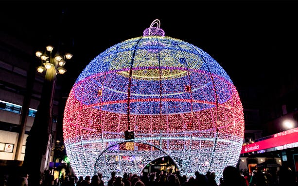 Giant illuminated Christmas ornament in Paris street.