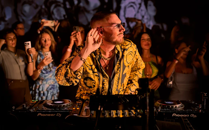DJ performing at Make the Girls Dance event in Ibiza, surrounded by an engaged crowd.