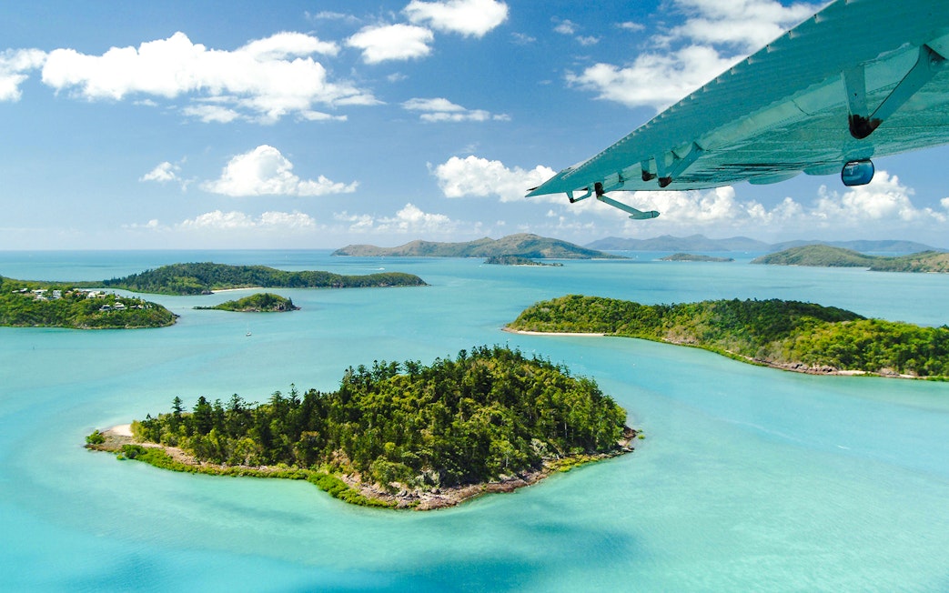 Aerial view of Heart Island in the Whitsundays with turquoise waters and lush greenery.